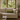 Beige sofa with a Harris Tweed Olive lumbar cushion in a room with large windows showing a garden view.