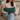 Woman holding a Harris Tweed Peacock lumbar cushion on a couch in a cozy living room.