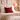 Harris Tweed Royal Stewart Tartan cushion and a blanket on a bed, with a softlyn lit lamp on a nightstand