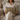 Woman holding a Harris Tweed Sollas Tartan lumbar cushion on a couch in a cozy living room setting