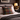 Harris Tweed Stornoway Tarton cushion on a bed with a lamp and decor in the background