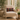 Beige armchair with a Harris Tweed Stornoway Tartan lumbar cushion in a room with large windows and potted plants.
