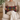 Woman holding a Harris Tweed Stornoway Tartan lumbar cushion on a beige couch in a cozy living room.