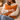 Woman holding a Harris Tweed Terracotta cushion in a cozy indoor setting