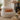 Beige bean bag chair with a Harris Tweed Terracotta lumbar cushion, in a cozy living room with a fireplace.
