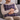 Man holding a Harris Tweed Thistle and Flint Wave cushion on a gray couch