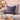 Harris Tweed Thistle and Flint Wave cushion on a gray sofa with a coffee cup and decor items in a living room.