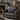Gray armchair with a Harris Tweed Thistle & Flint Wave lumbar cushion in a cozy living room setting.