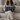 Woman holding a Harris Tweed Thistle & Flint Wave lumbar cushion on a couch in a living room setting