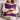 Woman holding a Harris Tweed Thistle purple cushion on a gray couch