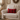 Cozy living room with a beige armchair, Harris Tweed Winterberry Tartan lumbar cushion, and decorative elements.